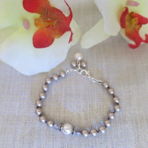 Eleganta rokasspradze ar Swarovski platīn-krāsas pērlēm un dekoratīvu elementu ar Swarovski krēmkrāsas pērlīti un Swarovski kristāliem, aizdare ar sudraba pārklājumu. Garums- 18-19 cm